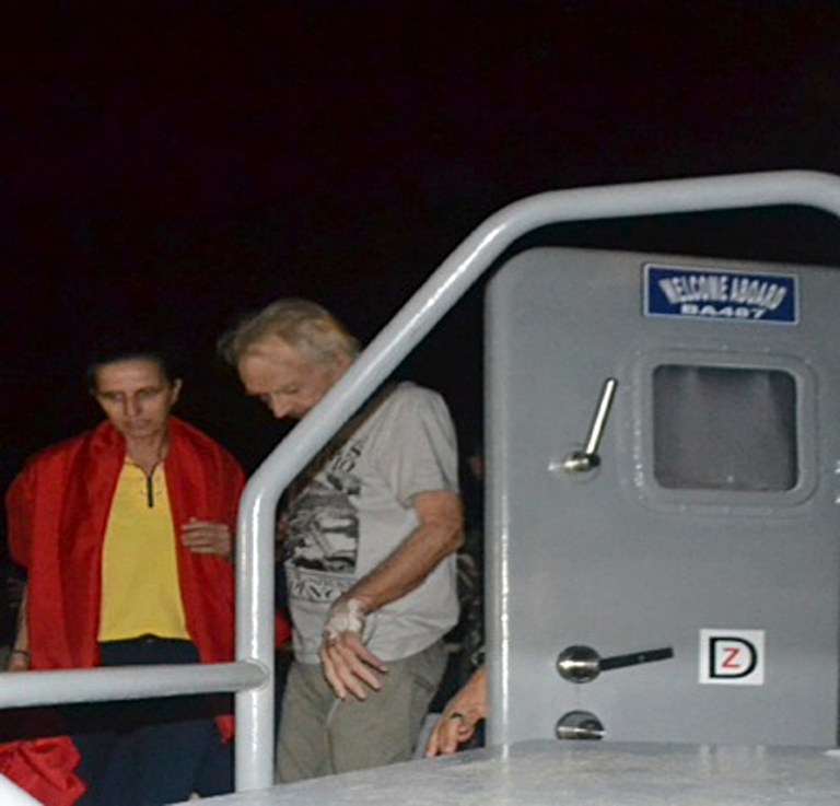 In this photo released by the Armed Forces of the Philippines, kidnapped German nationals Stefan Okonek, right, and female companion Henrike Dielen disembark from the Philippine Navy vessel upon arrival at dawn Saturday, Oct. 18, 2014, at the Western Mindanao Command in Zamboanga city in southern Philippines. Okonek and Dielen, who had been kidnapped and held for six months in the southern Philippines were released Friday by the militant group just hours after it had threatened to behead one of them if no ransom payment was made, the Philippine defense chief said. (AP Photo/Armed Forces of the Philippines Western Mindanao Command) EDITORIAL USE ONLY
