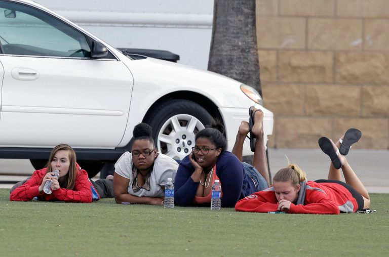 University of Central Florida students wait outside the college sports arena after explosive devices were found in a nearby dorm, Monday, March 18, 2013, in Orlando, Fla. The campus was closed and classes were postponed until noon. (AP Photo/John Raoux)