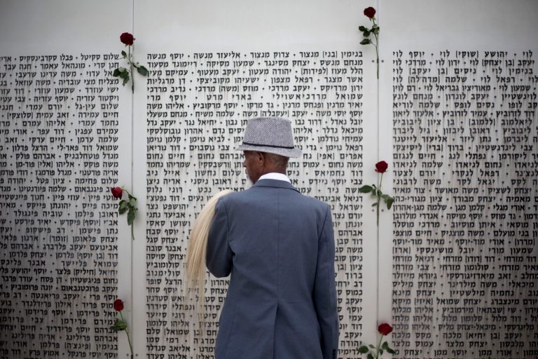 An Ethiopian Jew looks at the wall of names at the Armored Corps memorial for fallen soldiers before a ceremony marking the annual Memorial Day for soldiers and civilians killed in more than a century of conflict between Jews and Arabs, in Latrun near Jerusalem, Israel, Monday, May 5, 2014. Israel came to a standstill on Monday as sirens wailed across the country on its annual Memorial Day for fallen soldiers and victims of terrorism. (AP Photo/Ariel Schalit)
