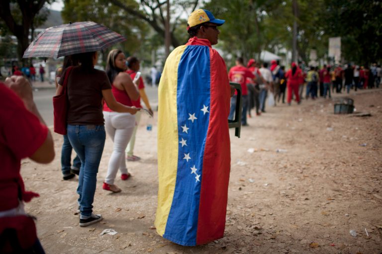People queue outside the military academy to see the body of Venezuela's late President Hugo Chavez lying in state in Caracas, Venezuela, Sunday, March 10, 2013. Chavez died of cancer on March 5. He was 58. (AP Photo/Ariana Cubillos)