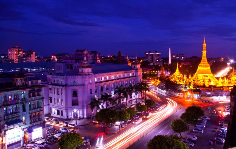In this long exposure photo, vehicles make their way on a road as the Sule pagoda is illuminated in downtown Yangon, Myanmar, Wednesday, Sept. 24, 2014. (AP Photo/Khin Maung Win)