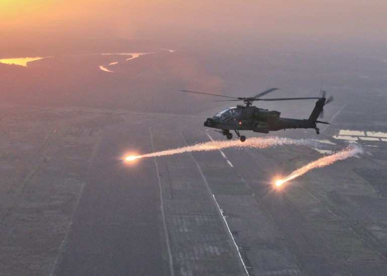 FILE - This Oct. 8, 2011, photo released by the U.S Army National Guard shows an AH-64D Apache Longbow with the South Carolina Army National Guard releasing flares during a test over Camp Tajo, Iraq. The Army has lost an initial Senate skirmish over a hotly disputed plan to take Apache attack helicopters away from National Guard units in a budget cutting move that has infuriated governors and state military leaders. (AP Photo/U.S. Army National Guard, Tracci Dorgan)