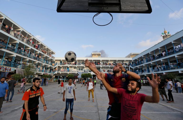 Palestinian displaced people play basketball in the courtyard of a U.N. school at Jebaliya refugee camp, in the northern Gaza Strip, Tuesday, July 29, 2014. The school is one of dozens of emergency shelters for those who have fled the fighting. About 180,000 Palestinians_about 10 percent of the entire population of Gaza_are seeking shelter in over 80 UNRWA schools, according to United Nations' Office for the Coordination of Humanitarian Affairs' July 28 report. (AP Photo/Lefteris Pitarakis)
