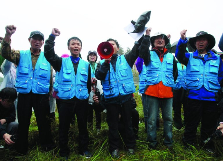North Korean defectors shout slogans as police officers block their planned rally on a road in Paju near demilitarized zone, South Korea, Monday, Oct. 22, 2012. South Korea has banned activists from launching propaganda leaflets to North Korea after North Korea threatened to attack.(AP Photo/Ahn Young-joon)