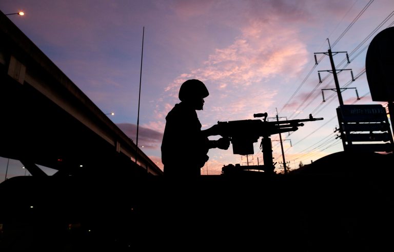 A Thai soldier mans his machine gun atop a military vehicle outside the Centre for the Administration of Peace and Order (CAPO) after soldiers were sent in to seize the center Tuesday, May 20, 2014 in Bangkok, Thailand. Thailand's army declared martial law in a surprise announcement in Bangkok before dawn on Tuesday, intensifying the turbulent nation's deepening political crisis. The military, however, denied a coup d'etat was underway. (AP Photo/Wason Wanichakorn)