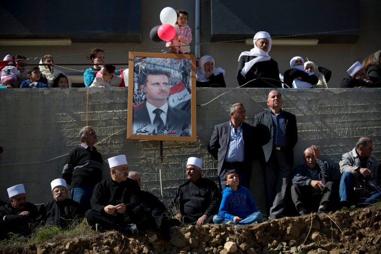 Druse supporters of Syrian President Bashar Assad hold up his portraits during a rally, demanding the return of the Golan Heights, captured by Israel in 1967, close to the Syrian border in Majdal Shams in the Golan Heights, Friday, Feb. 14, 2014. The annual demonstration is in protest of the 1981 Israeli law in which the Jewish state annexed the strategic plateau it captured from Syria during 1967 Arab-Israeli war. (AP Photo/Oded Balilty)