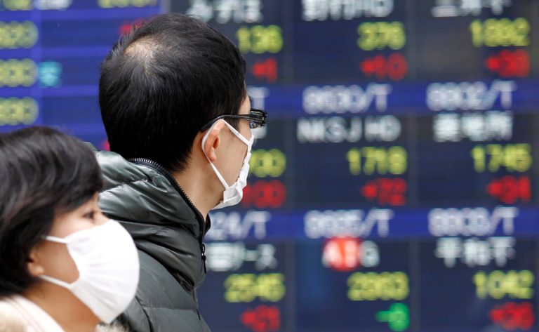   People walk by a stock price display of a securities firm in Tokyo Monday, Dec. 17, 2012. Japan's Nikkei 225 index jumped 1.6 percent to 9,891.15, its highest level since April, after the country's Liberal Democratic Party swept back into power at weekend elections. (AP Photo/Koji Sasahara)  