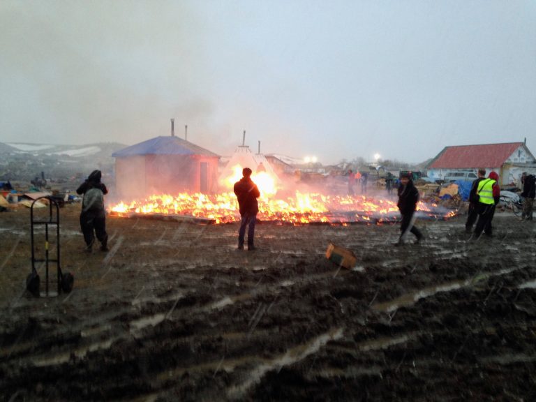 Some protesters left the North Dakota encampment as a federal deadline approached, while others set fires. (AP Photo/James MacPherson)
