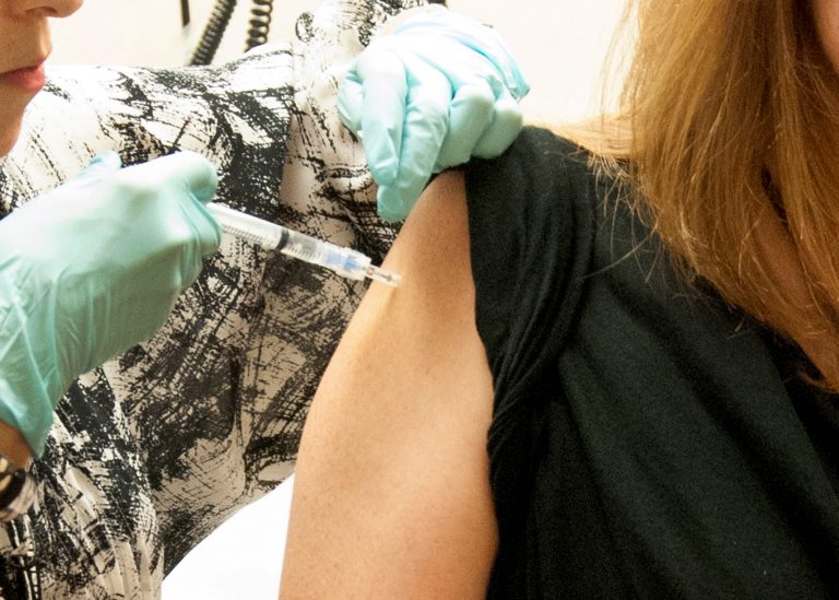FILE - This handout file photo taken Sept. 2, 2014, provided by National Institute of Allergy and Infectious Diseases (NIAID) shows a 39-year-old woman, the first participant enrolled in VRC 207, receiving a dose of the investigational NIAID/GSK Ebola vaccine at the National Institute of Health (NIH) Clinical Center in Bethesda, Md.  The hope is that the first human safety study of the vaccine might eventually be used in the current Ebola outbreak in West Africa. New monkey studies show that one shot of an experimental Ebola vaccine can trigger fast protection, but the effect waned unless the animals got a booster shot made a different way.  (AP Photo/NIAID, File)