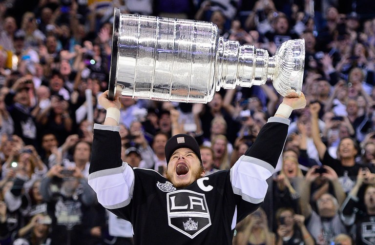   Los Angeles Kings right wing Dustin Brown (23) holds up the Stanley Cup after the Kings beat the New Jersey Devils 6-1 during Game 6 of the NHL hockey Stanley Cup finals, Monday, June 11, 2012, in Los Angeles. (AP Photo/Mark J. Terrill)  