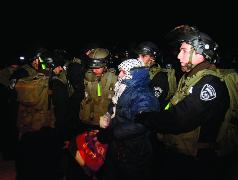 Israeli border police evict a Palestinian activist from an area known as E-1 near Jerusalem, Sunday, Jan 13, 2013. Palestinian activists erected tents in the area on Friday saying they wanted to 