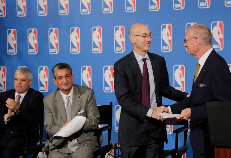 ESPN President John Skipper, right, shakes hands with  NBA Commissioner Adam Silver, second right, as David Levy, left, President of Turner Broadcasting System, and Ted Leonsis, second left, owner of the Washington Wizards, applaud after a deal was announced between the league and TV networks, Monday, Oct. 6, 2014 in New York. The NBA has extended its television deals with ESPN and TNT for nine years. The league announced Monday that the new contracts will run through the 2024-25 season. The previous eight-year agreements end after the 2015-16 season. (AP Photo/Mark Lennihan)