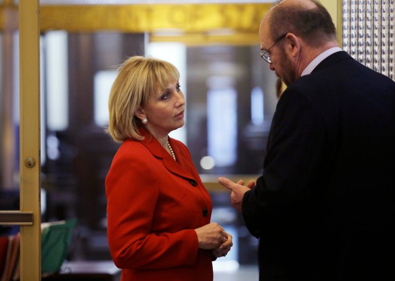 New Jersey Lt. Gov. Kim Guadagno, left, listens to a question as she stands outside the office of the New Jersey Department of State in the Statehouse in Trenton, N.J., Tuesday, Jan. 28, 2014. Guadagno is also concurrently the secretary of state of New Jersey. (AP Photo/Mel Evans)
