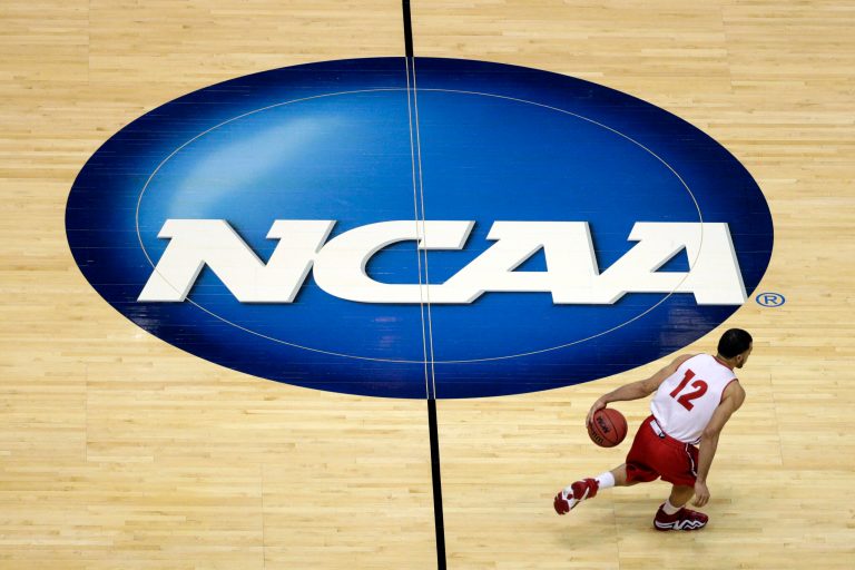 FILE - In this March 26, 2014, file photo, Wisconsin's Traevon Jackson dribbles past the NCAA logo during practice at the NCAA men's college basketball tournament in Anaheim, Calif. A federal judge ruled that the NCAA can't stop players from selling the rights to their names, images and likenesses, striking down NCAA regulations that prohibit them from getting anything other than scholarships and the cost of attendance at schools. U.S. District Judge Claudia Wilken in Oakland, Calif., ruled in favor Friday, Aug. 8, of former UCLA basketball star Ed O'Bannon and 19 others in a lawsuit that challenged the NCAA's regulation of college athletics on antitrust grounds. (AP Photo/Jae C. Hong, File)