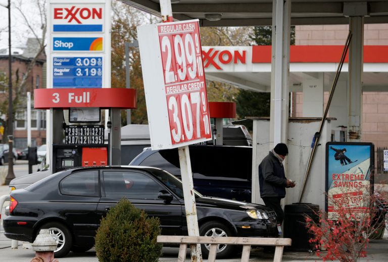 A gas station employee counts money as he walks away from pumping a vehicle at the intersection of State Highway 139 and John F. Kennedy Boulevard in Jersey City, N.J., where a Lukoil gas station advertises gas for $2.99, Tuesday, Nov. 12, 2013. (AP/Julio Cortez)