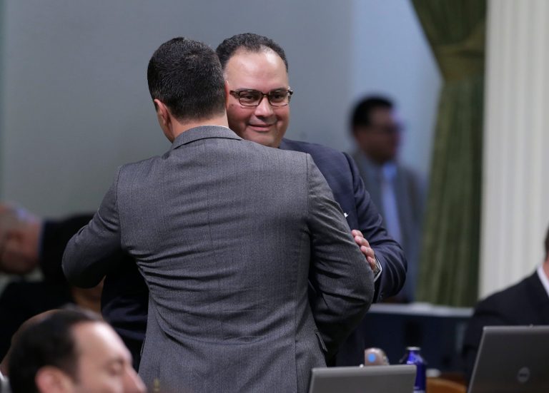 Assemblyman John Perez, D-Los Angeles, receives congratulations from Assemblyman Mike Gatto, D-Los Angeles, after his measure to place a rainy day fund on the November ballot was approved by the Assembly in  Sacramento, Calif., Thursday, May 15, 2014.  Lawmakers in both houses approved the bill Perez negotiated before stepping down as speaker this week  It places a proposed constitutional amendment before the voters that will create a budget reserve funded primarily from excess capital gains revenue during boom years as well as an annual contribution equal to 1.5 precent of the state's general fund. (AP Photo/Rich Pedroncelli)