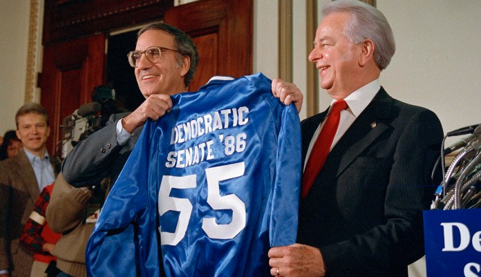 Sen. George Mitchell, D-Maine, left, presents a jacket imprinted with the words "Democratic Senate '86" to Sen. Robert Byrd, D-W.Va., on Capitol Hill, Nov. 6, 1986. (AP Photo/Lana Harris)