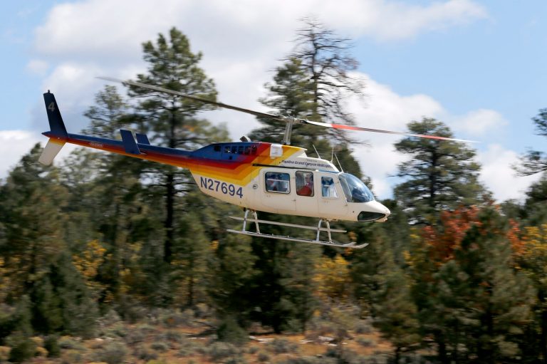 In this Oct. 11, 2013 photo, a tour helicopter takes off at Grand Canyon National Park Airport in Tusayan, Ariz. Air tour operators that use aircraft with quiet technology will be able to fly more people over the Grand Canyon. The Federal Aviation Administration said it plans to release 1,721 flight allocations this year that had been abandoned to those commercial tour operators, as long as their active fleet doesn't increase noise in the park overall. (AP Photo/Ross D. Franklin)