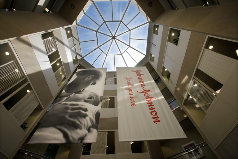 In this Tuesday, July 30, 2013, photo, large banners hang in an atrium at the headquarters of Johnson & Johnson in New Brunswick, N.J. Johnson & Johnson reports quarterly financial results before the market opens on Tuesday, Jan. 21, 2014. (AP Photo/Mel Evans)