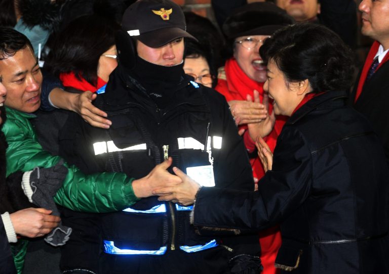   South Korea's presidential candidate Park Geun-hye of the ruling Saenuri Party shakes hands with a supporter as she leaves her home to head to her office in Seoul, South Korea, Wednesday, Dec. 19, 2012. (AP Photo/Yonhap) KOREA OUT  