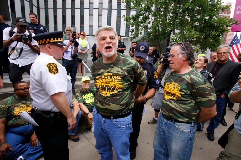 United Mine Workers International President Cecil Roberts, center, is arrested by Pittsburgh Police for blocking the sidewalk in front of the William S. Moorehead Federal Building after leading a march of union members and supporters through the streets of downtown Pittsburgh in support of American energy and jobs in the coal and related industries Thursday, July 31, 2014. Fourteen United Mine Workers members, including international president Roberts, were arrested. They were to be cited and released for blocking a sidewalk. (AP Photo/Gene J. Puskar)