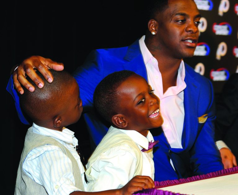 Richard Lipski/AP
Clinton Portis announced his retirement from the Washington Redskins with sons Camdin, left, and Chaz on Thursday.