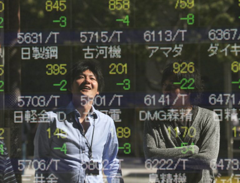 People are reflected on the electronic board of a securities firm in Tokyo, Tuesday, Oct. 14, 2014. Shares rose in Asia on Tuesday as investors encouraged by strong China trade shrugged off a tumble on Wall Street triggered by fears that slowing growth in Europe and Asia could hobble the global recovery. (AP Photo/Koji Sasahara)