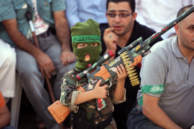 A Palestinian boy holds a toy gun during a celebration organized by Hamas in the West Bank city of Nablus, on Friday, Aug. 29, 2014.    Israel and Hamas militants fought for 50 days before reaching a truce on Tuesday.  Palestinian President Mahmoud Abbas has accused Hamas of needlessly extending fighting in the Gaza Strip, causing a high death toll. (AP Photo/Nasser Ishtayeh)
