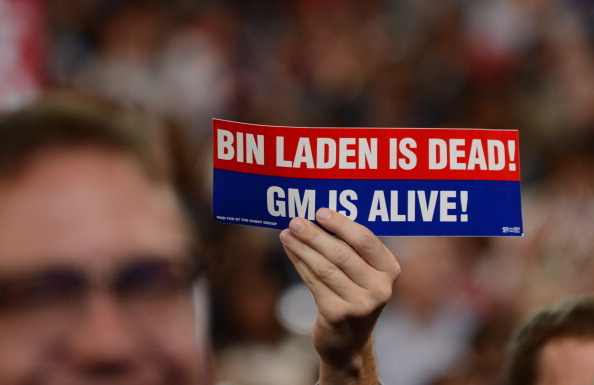A man holds up a sign reading 