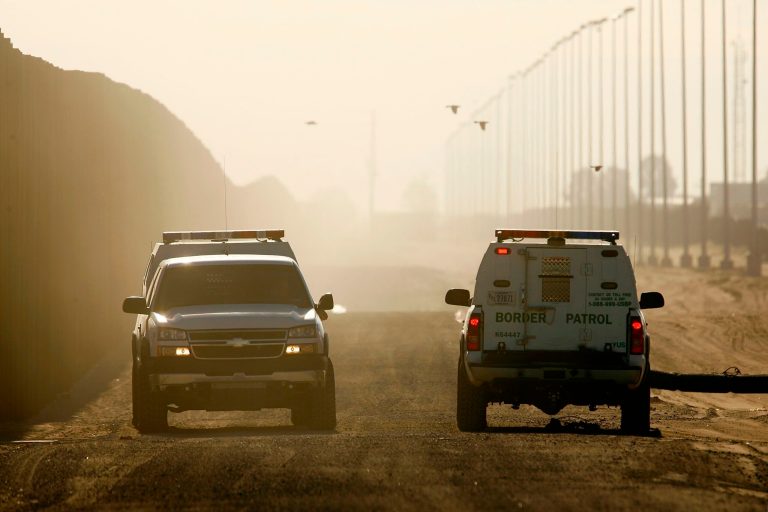 Border Patrol vehicles patrol along a barrier that runs along the US-Mexico border on October 4, 2007 east of San Luis, Calif. (Photo by David McNew/Getty images)