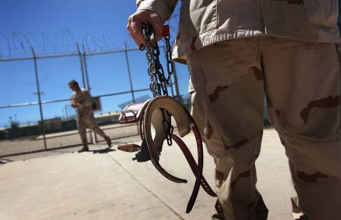 A U.S. military guard carries shackles before moving a detainee inside the U.S. detention center for 'enemy combatants' on September 16, 2010 in Guantanamo Bay, Cuba. (Photo by John Moore/Getty images)
