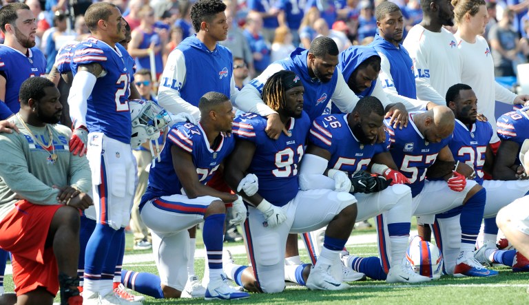 It started with Colin Kaepernick and his silent protest against social injustice. Now the kneeling's about more than that: It's about Donald Trump, a corrupt system, and the type of country we want to be. The most patriotic thing you can do right now is not salute the flag. (AP Photo/Adrian Kraus)