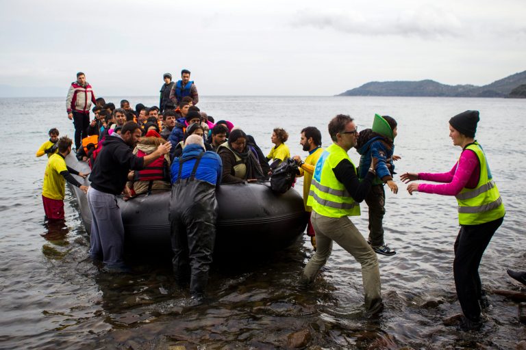 Refugees are helped by volunteers as they arrive on the Greek island of Lesbos after crossing the Aegean Sea from Turkey. Lawmakers are pushing legislation, which President Obama has threatened to veto, that would impose more restrictions on a plan to accept 10,000 refugees from Syria in fiscal 2017. (Photo by Tasos Markou/NurPhoto via AP)