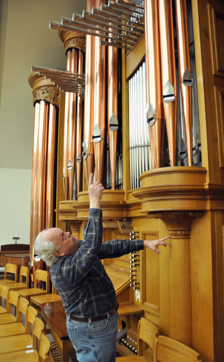   In this Friday, Nov. 30, 2012 photo, organ builder John Nordlie points at some of the towering pipes on an instrument he built for First United Methodist Church, in Sioux Falls, S.D. The pipe organ has ruled the Christian worship sanctuary for centuries, but a growth in praise-band worship services and a nationwide shortage of qualified organists are prompting many congregations to leave the majestic instrument out of their new building construction plans. But organ aficionados say they see a bright future for the instrument. (AP Photo/Dirk Lammers)  