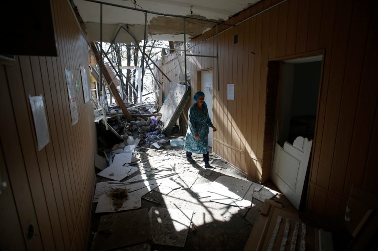 A woman shows the damage caused to a hospital in the village of Novosvitlivka, eastern Ukraine, Monday, Sept. 15, 2014. The village was severely damaged during fighting between government troops and the separatist rebels that eventually took control there in late August. (AP Photo/Darko Vojinovic)