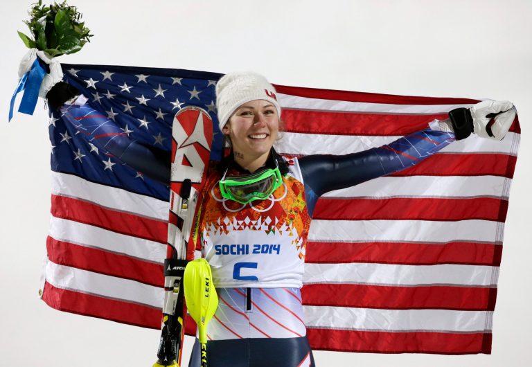 Women's slalom gold medal winner Mikaela Shiffrin of the United States poses for photographers with the U.S. flag at the Sochi 2014 Winter Olympics, Friday, Feb. 21, 2014, in Krasnaya Polyana, Russia.(AP Photo/Gero Breloer)