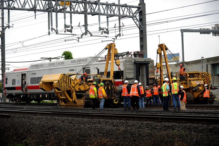 A derailed Metro-North rail car is hoisted back on to the tracks in Bridgeport. Conn. on Sunday, May 19, 2013. Crews will spend days rebuilding 2,000 feet of track, overhead wires and signals following the collision between two trains Friday evening that injured 72 people, Metro-North President Howard Permut said Sunday. (AP Photo/The Connecticut Post,Brian A. Pounds ) MANDATORY CREDIT