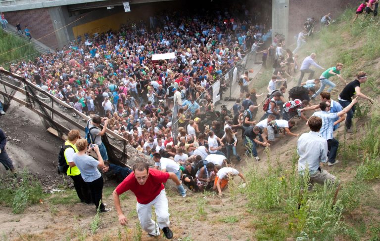 FILE - In this July 24, 2010 file picture people flee during a mass panic  at  a techno festival in Duisburg, Germany. German prosecutors say they have indicted 10 people on charges including involuntary manslaughter over a mass panic at the Love Parade techno music festival nearly four years ago that resulted in 21 deaths. Duisburg prosecutor Horst Bien said Wednesday Feb. 12, 2014  that four employees of the event's organizers and six city workers have been indicted. They face charges of involuntary manslaughter and bodily harm, punishable with up to five years jail time.  (AP Photo/dpa,Erik Wiffers,File)