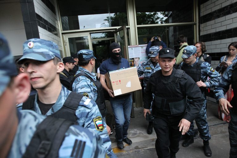   An investigator guarding by Russian police officers carries a box after a police search in Russian opposition leader Alexei Navalny flat in Moscow, Russia, June 11, 2012. Russian investigators searched the apartments of several protest leaders Monday and called them in for questioning Tuesday, making it difficult if not impossible for them to lead a mass demonstration against President Vladimir Putin planned for the June 12 national holiday. (AP Photo/Leonid Lebedev)  