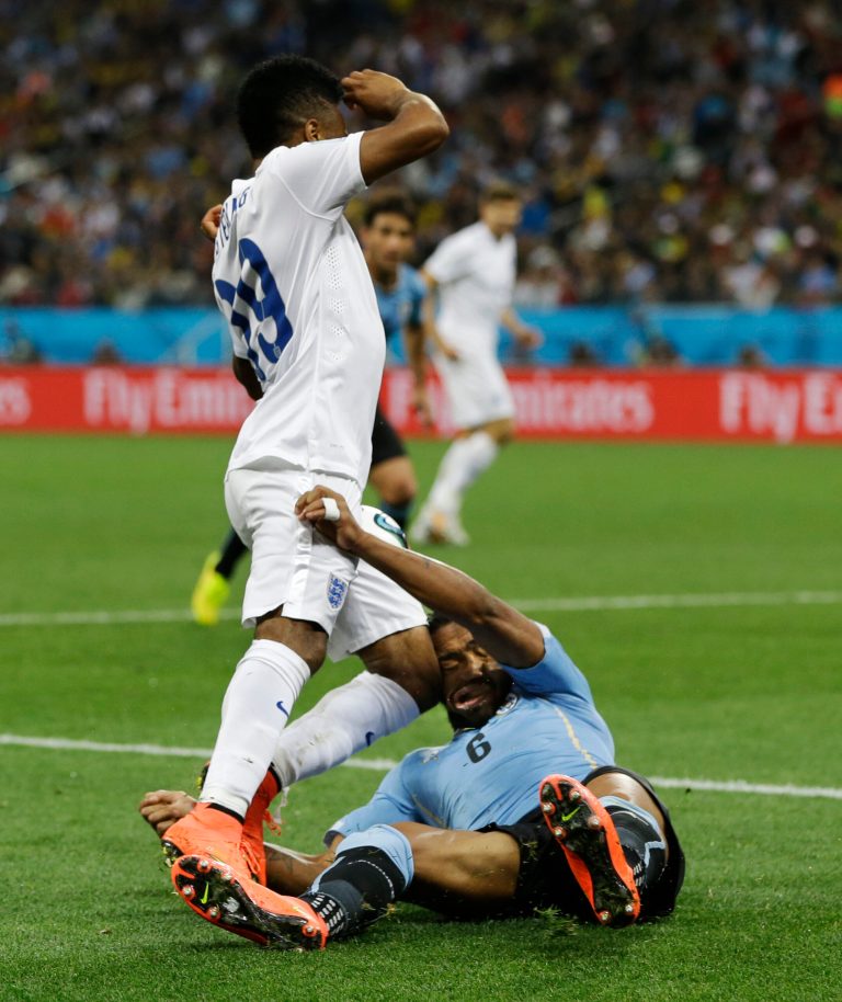 England's Raheem Sterling runs into Uruguay's Alvaro Pereira with his knee during the group D World Cup soccer match between Uruguay and England at the Itaquerao Stadium in Sao Paulo, Brazil, Thursday, June 19, 2014. Pereira was knocked out by the blow.  (AP Photo/Kirsty Wigglesworth)