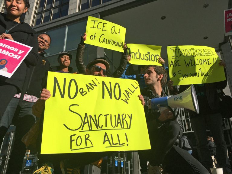 Protesters hold up signs outside a courthouse where a federal judge was to hear arguments in the first lawsuit challenging President Donald Trump's executive order to withhold funding from communities that limit cooperation with immigration authorities in San Francisco. (AP Photo/Haven Daley, File)