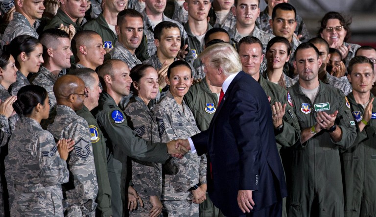 President Trump shakes hands with military airmen in an aircraft hangar at Joint Base Andrews, Md. (Andrew Harrer/Bloomberg)