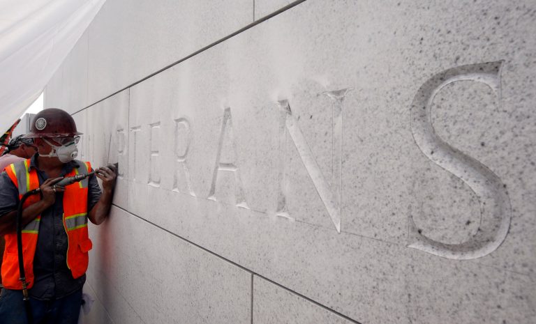 Paul Russo, with the John Stevens Shop, works on the letters for the Disabled Veterans' Life Memorial, Monday, July 21, 2014 in Washington. The memorial is scheduled to be dedicated in October. (AP Photo/Alex Brandon)