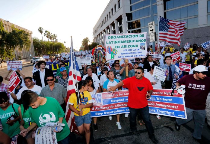Protesters march on Wednesday, May 1, 2013, in downtown Phoenix during a May Day rally to show support for national immigration reform. (AP Photo/Matt York)