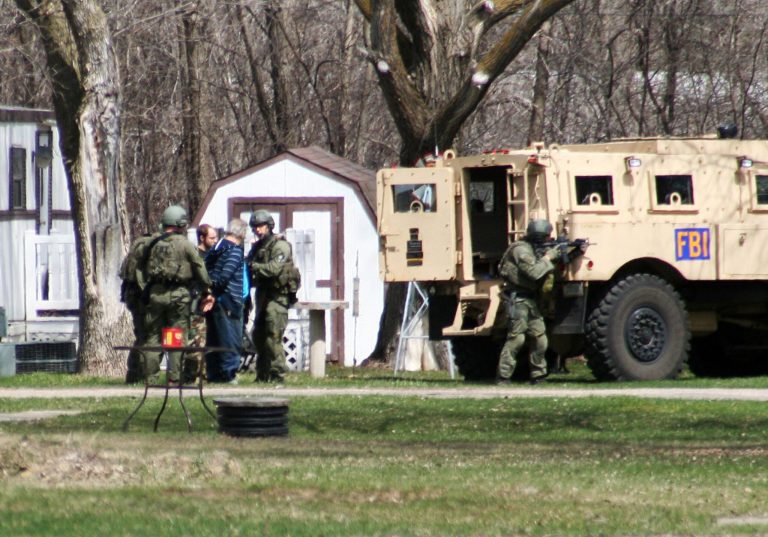 This May 3, 2013, photo provided by Jeremy Jones shows FBI agents with Buford Rogers, back left, and an unidentified man during a raid on a mobile home in Montevideo, Minn. Authorities said Monday, May 6, that Rogers was arrested Friday and that the agency believes is disrupted a potential terror attack after a search of the home turned up Molotov cocktails, suspected pipe bombs and firearms. (AP Photo/Montevideo American-News, Jeremy Jones) MANDATORY CREDIT