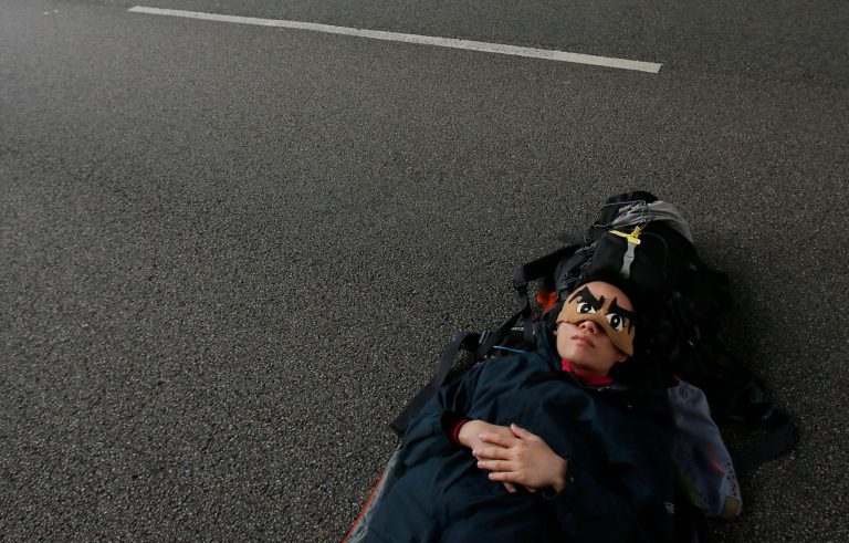 AP10ThingsToSee - A pro-democracy student protester sleeps on an occupied roadway surrounding the government complex in Hong Kong, Tuesday, Oct. 7, 2014. Student-led protests for democratic reforms in Hong Kong continued, and has blocked main roads in the Asian financial hub for nearly two weeks. (AP Photo/Wally Santana)