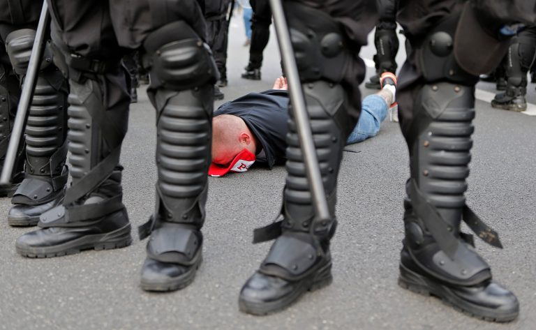   A handcuffed Polish fan lies flat on the street prior to the Euro 2012 soccer championship Group A match between Poland and Russia in Warsaw, Poland, Tuesday, June 12, 2012. Russian soccer fans clashed with police and Poland supporters in separate incidents in Warsaw on Tuesday, just hours before the two teams were to meet in an emotionally charged European Championship match. Several people were injured. (AP Photo/Gero Breloer)  