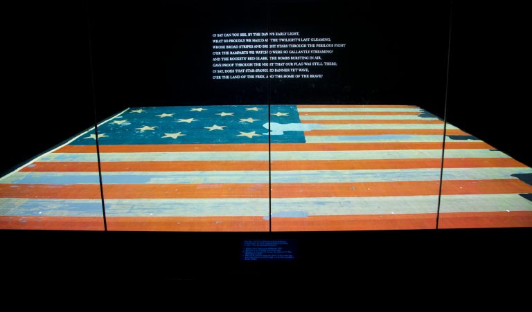 This photo taken Sept. 5, 2014 shows the Smithsonian's National Museum of American History in Washington exhibit of the flag that inspired the national anthem 'Star-Spangled Banner'. Years ago parts of the flag were snipped off and handed out as mementos and the Smithsonian has been reacquiring some of those fragments and adding to their collection. (AP Photo/Pablo Martinez Monsivais)