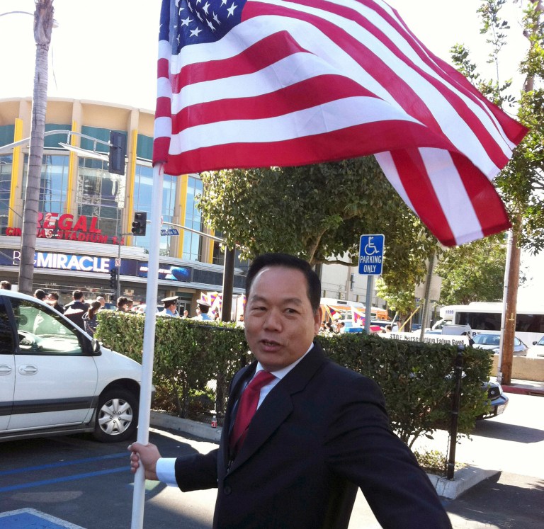 FILE - In this Feb. 16, 2012 file photo released by Anna Wu, American businessman Vincent Wu poses with an American flag as he waits to welcome China's then-Vice President Xi Jinping on his visit to Los Angeles, Calif. A Chinese court sentenced Vincent Wu on Thursday, May 15, 2014 to 20 years in prison on charges of heading a mob that kidnapped rivals and operated illegal casinos, and rejected his claim that he was tortured by police. (AP Photo/Courtesy of Anna Wu, File)