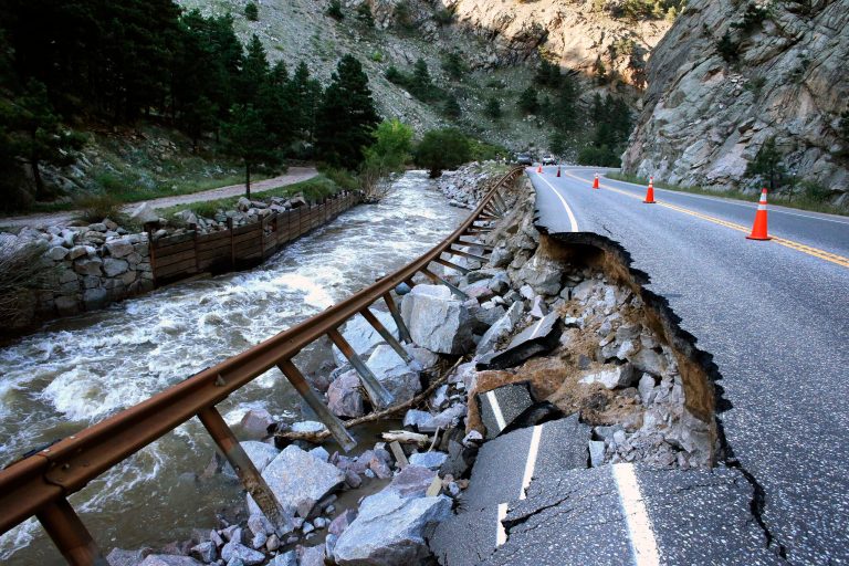 FILE - In this Sept. 20, 2013, file photo, a guardrail hangs away from a closed canyon road, which links Boulder with the mountain town of Nederland, and which is washed out in places by recent flooding, up Boulder Canyon, west of Boulder, Colo. When it comes to climate change, local officials have a message for Washington: Lead or get out of the way. Matthew Appelbaum, mayor of Boulder, Colo., says the first thing the federal government should do is not make things worse. He says officials should reconsider policies that encourage rebuilding in flood zones and forested areas vulnerable to wildfires.(AP Photo/Brennan Linsley, File)